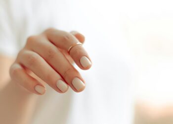 persons hand with white manicure