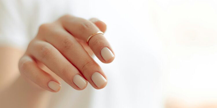 persons hand with white manicure